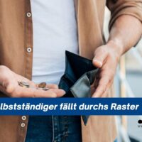 unger Solo-Selbstständiger mit leerer Geldbörse und wenigen Münzen in der Hand als Symbol für Armut und abgelehntes Bürgergeld.